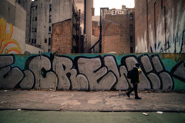 A photo of someone walking by graffiti on the Lower East Side